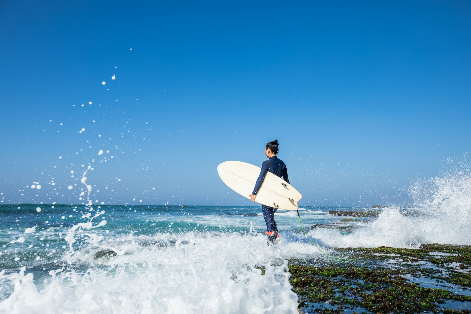 Surfer with surfboard at seaside